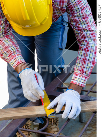Man using a try square to mark and measure a 69803417