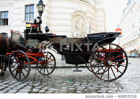 Horse-driven carriage at Hofburg palace, Vienna, Austria Horse-driven carriage at Hofburg palace, Vienna, Austria 69803558