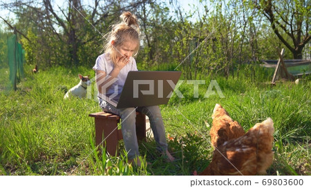 little girl with laptop and chickens in village little girl with laptop and chickens in village 69803600