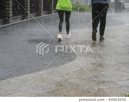 Pedestrian in the rain 69803656