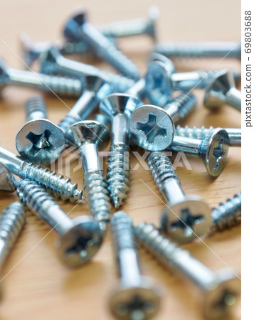 Silver screws and wooden board background Silver screws and wooden board background 69803688