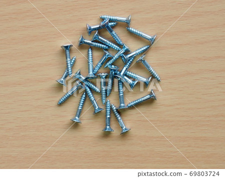 Silver screws and wooden board background Silver screws and wooden board background 69803724