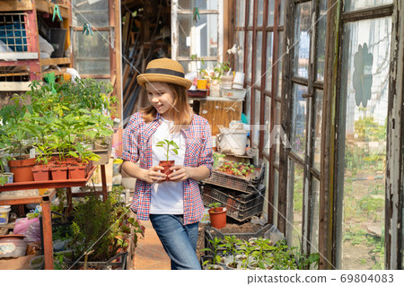 Adorable teen girl kid in hat with seedlings Adorable teen girl kid in hat with seedlings 69804083