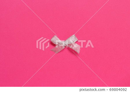 Silver bow on a pink background 69804092