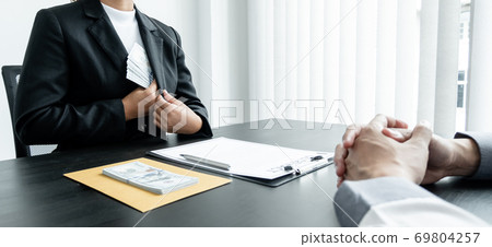 Businessmen make an agreement with the money proposed by his partner to bribe in the company. The concept of corruption Businessmen make an agreement with the money proposed by his partner to bribe in the company. The concept of corruption 69804257