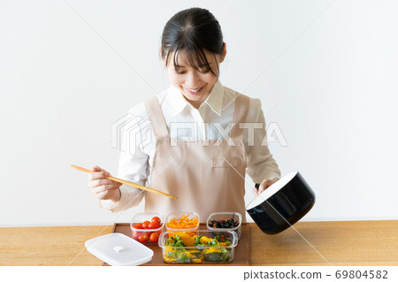 Young woman making side dishes Young woman making side dishes 69804582