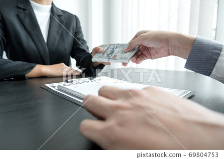 A businessman who gives money to his partner to bribe the concept of bribery and corruption A businessman who gives money to his partner to bribe the concept of bribery and corruption 69804753