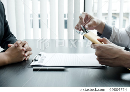 A businessman makes a deal with the money his partner offers to bribe the company, the concept of corruption A businessman makes a deal with the money his partner offers to bribe the company, the concept of corruption 69804754