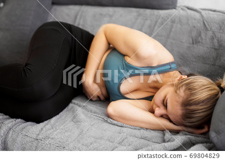 After the workout. Nice young woman sleeping on the sofa After the workout. Nice young woman sleeping on the sofa 69804829