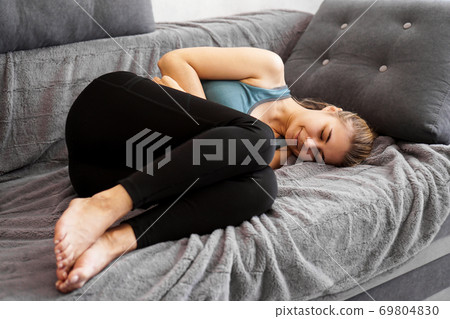 After the workout. Nice young woman sleeping on the sofa After the workout. Nice young woman sleeping on the sofa 69804830