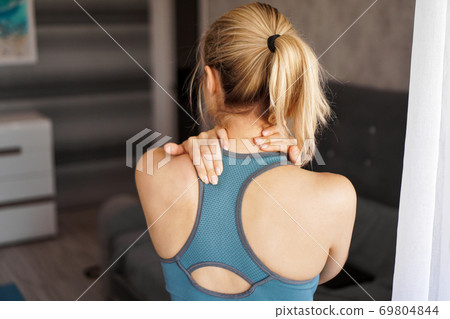 Sports injury concept. Athletic girl feeling pain in her neck Sports injury concept. Athletic girl feeling pain in her neck 69804844