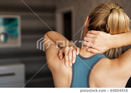 Sports injury concept. Athletic girl feeling pain in her neck Sports injury concept. Athletic girl feeling pain in her neck 69804856