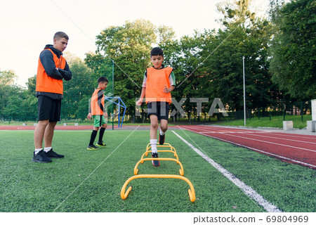 Children's football players during team training before an important match. Exercises for the youth football team. Children's football players during team training before an important match. Exercises for the youth football team. 69804969