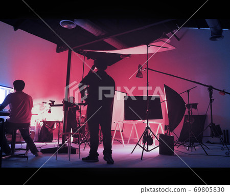 Two tone images of behind the scene of photo shooting production set up in the big studio. Professional crew team working and camera equipment in silhouette. And copy space added. 69805830
