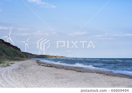 Wind wheels on sea and beach background. Wind energy. Alternative energy Wind wheels on sea and beach background. Wind energy. Alternative energy 69809494