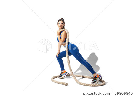 Beautiful young female athlete practicing on white studio background with shadows 69809849