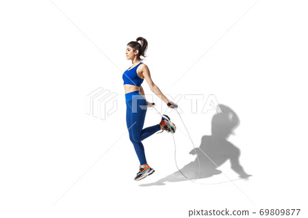 Beautiful young female athlete practicing on white studio background with shadows Beautiful young female athlete practicing on white studio background with shadows 69809877