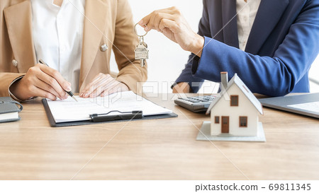 Estate agent holding a key and asking costumer for contract to buy, get insurance or loan estate. Estate agent holding a key and asking costumer for contract to buy, get insurance or loan estate. 69811345