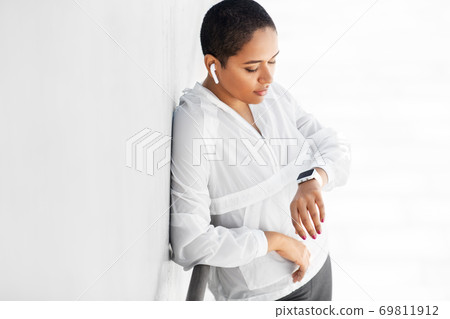 african woman with earphones and smart watch african woman with earphones and smart watch 69811912