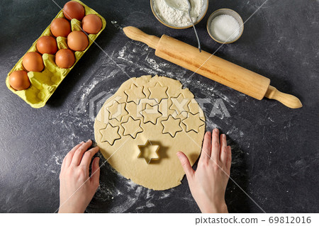 hands with shortcrust pastry dough and star mold hands with shortcrust pastry dough and star mold 69812016