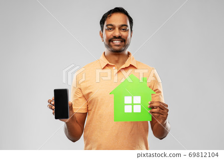 happy indian man with green house and smartphone 69812104