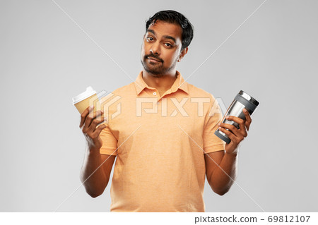 man comparing thermo cup or tumbler and coffee cup 69812107