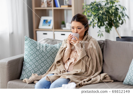 sad sick asian woman drinking hot tea at home 69812149