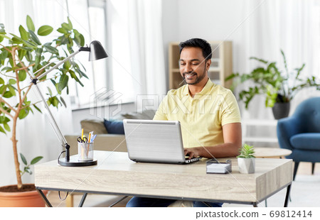 indian man with laptop working at home office 69812414