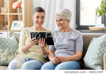 daughter and senior mother with tablet pc at home 69812447