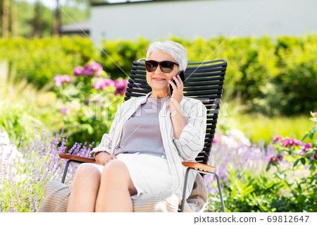 happy senior woman calling on phone at garden happy senior woman calling on phone at garden 69812647
