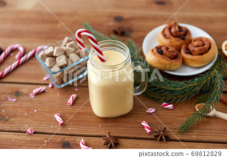 eggnog with candy cane in mug and cinnamon buns eggnog with candy cane in mug and cinnamon buns 69812829