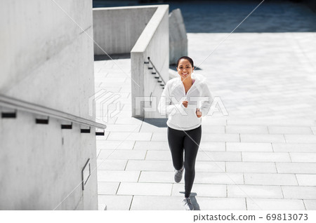 african american woman running upstairs outdoors 69813073