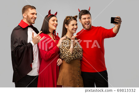 happy friends in halloween costumes taking selfie happy friends in halloween costumes taking selfie 69813332