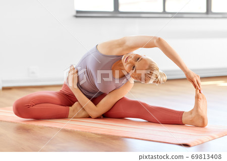 woman doing yoga and side bend pose at home woman doing yoga and side bend pose at home 69813408