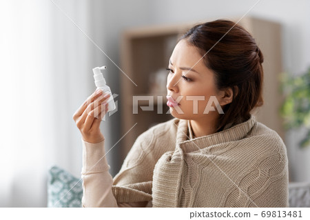 sick asian woman with oral spray medicine at home sick asian woman with oral spray medicine at home 69813481