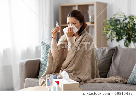 sick asian woman with nasal spray medicine at home sick asian woman with nasal spray medicine at home 69813482
