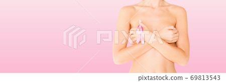 young woman checking breast for signs of cancer young woman checking breast for signs of cancer 69813543