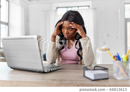 stressed woman with laptop working at home office 69813613