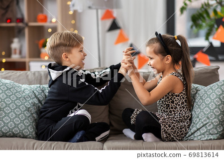 kids in halloween costumes having fun at home 69813614
