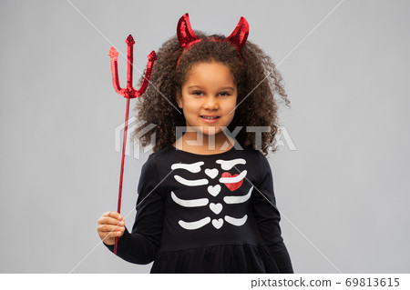girl with trident and devil's horns on halloween 69813615