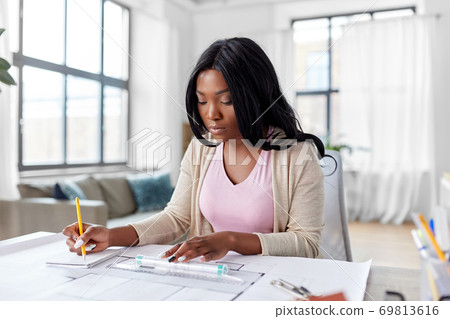 female architect with house model and blueprint 69813616