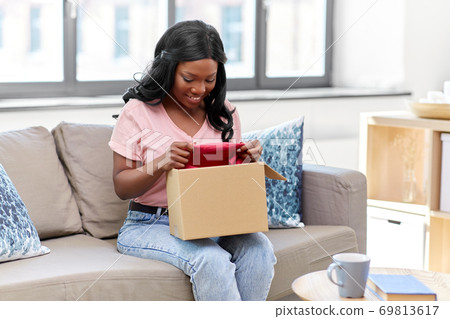 african american woman opening parcel box at home 69813617