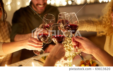 happy friends drinking red wine at christmas party 69813620