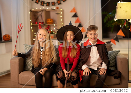 kids in halloween costumes at home at night kids in halloween costumes at home at night 69813622
