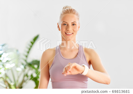 woman with smart watch at home or yoga studio 69813681