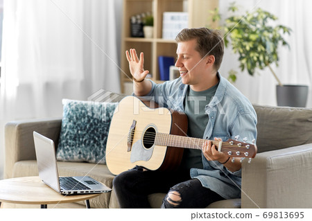 man with laptop and guitar having video call man with laptop and guitar having video call 69813695