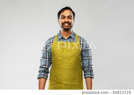 happy indian male gardener or farmer in apron 69813729