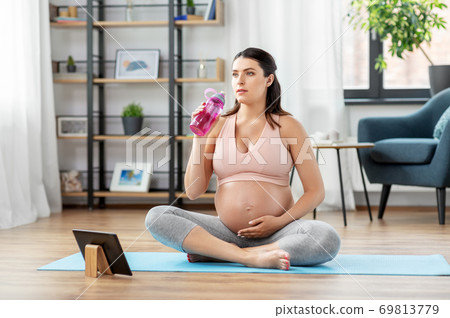 pregnant woman drinking water after yoga at home pregnant woman drinking water after yoga at home 69813779