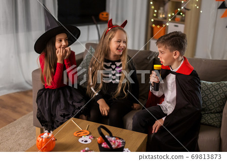 kids in halloween costumes playing at home kids in halloween costumes playing at home 69813873