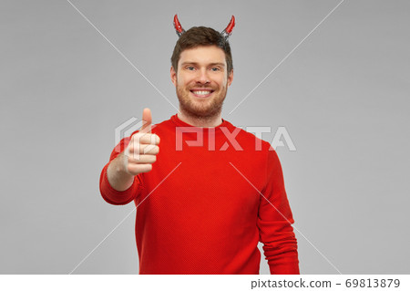 happy man in costume of devil showing thumbs up happy man in costume of devil showing thumbs up 69813879